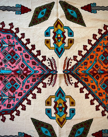 block printed cotton textile featuring vibrant pink, terracotta, mustard, and turquoise geometric patterns.