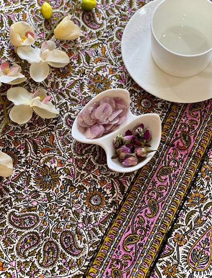 Block printed cotton textile in floral paisley design with treats and tea set.