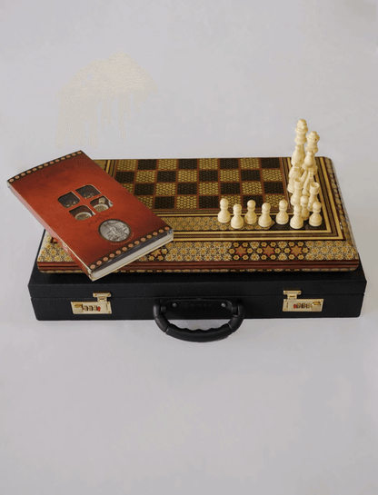 Khatam inlay chess and backgammon set displayed with chess pieces and playing cards on top.