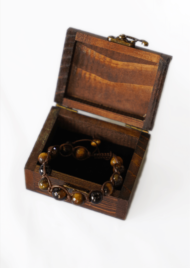 tiger's eye macrame bracelet displayed in a handmade wooden box, showcasing its natural gemstone beads.