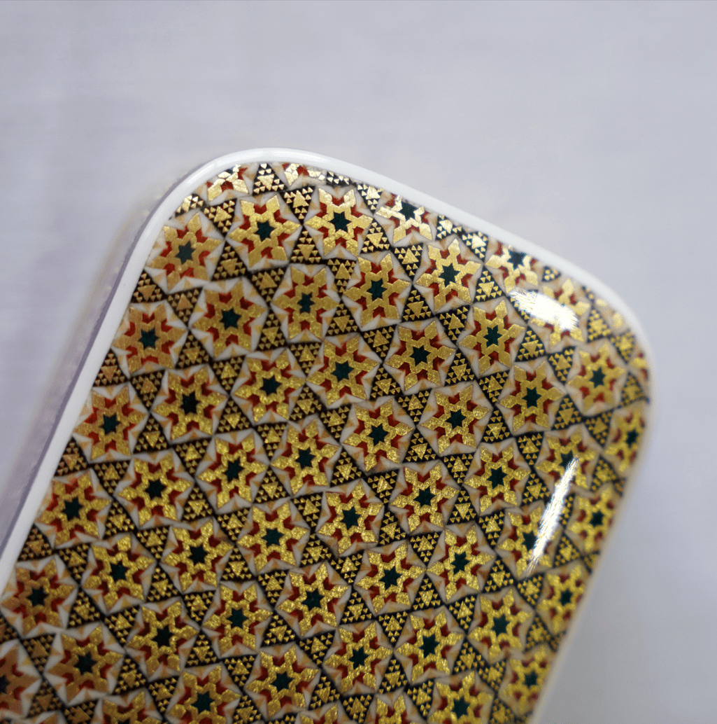 close-up of a patterned surface featuring intricate khatam marquetry design, showcasing geometric star motifs.