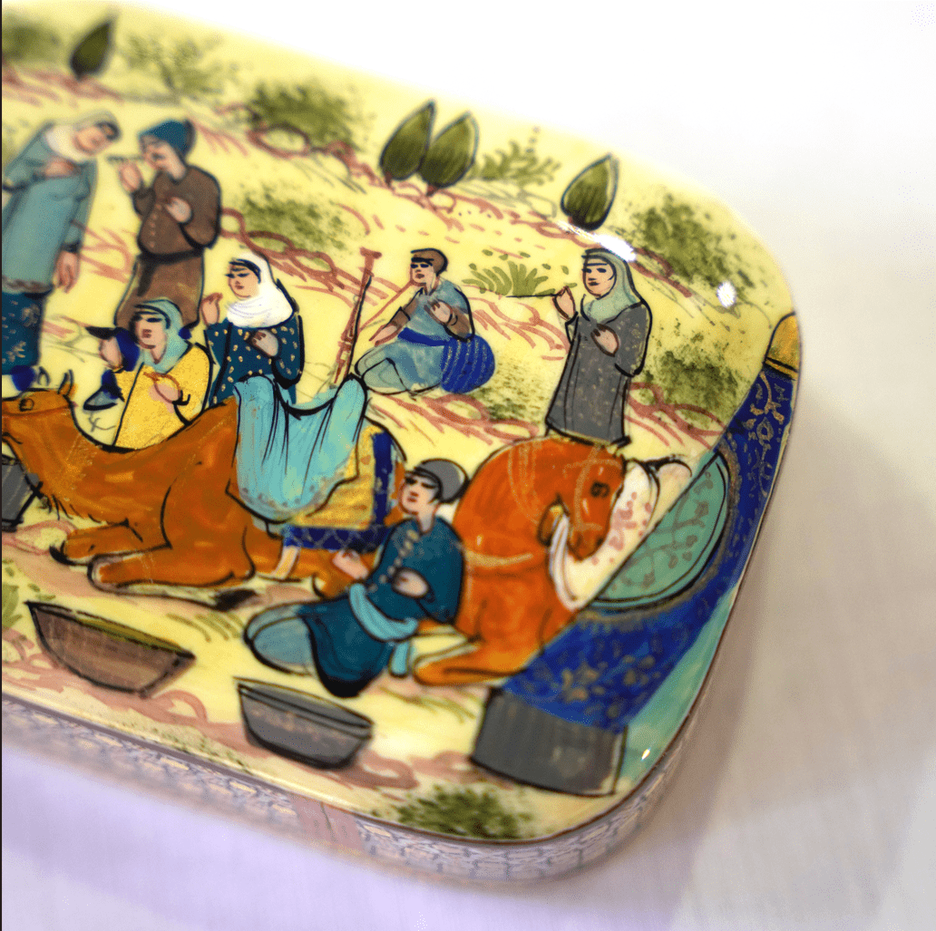 detailed view of the hand-painted design on a handmade wooden keepsake box featuring people and animals in a traditional scene.