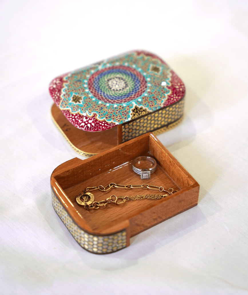 Handmade wooden trinket box with vibrant mandala artwork and jewelry inside, showcasing the Passori Collection.