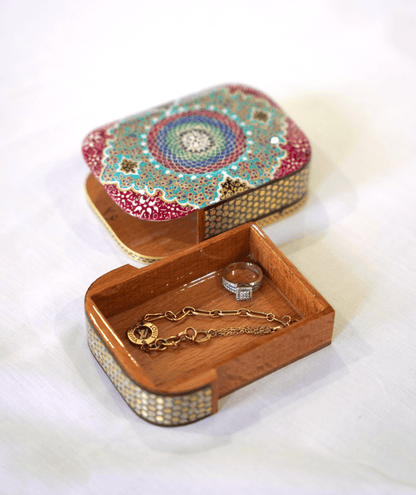 Handmade wooden trinket box with vibrant mandala artwork and jewelry inside, showcasing the Passori Collection.